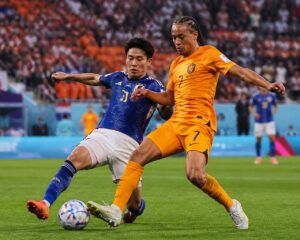 Hollanda ve Japonya takımları arasında bir Dünya Kupası maçında, oyuncular top için mücadele ediyor.