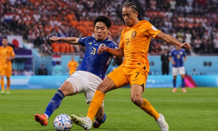 Hollanda ve Japonya takımları arasında bir Dünya Kupası maçında, oyuncular top için mücadele ediyor.