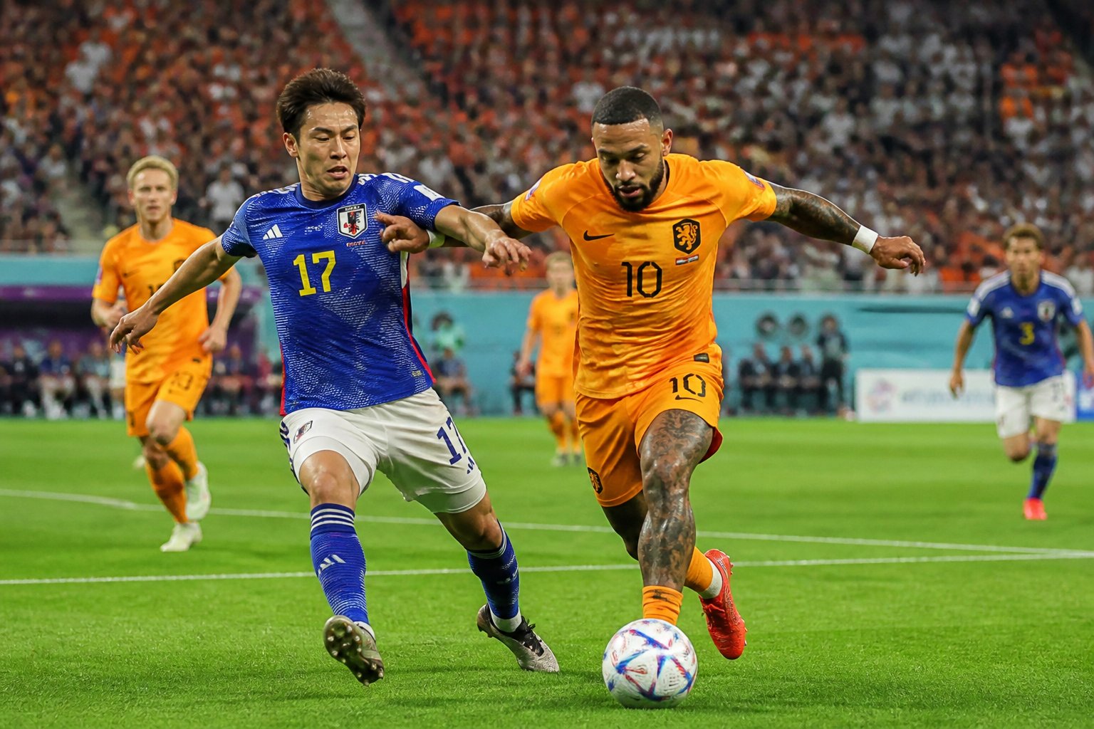 Hollanda ve Japonya futbol takımları arasında Dünya Kupası maçında saha üzerinde mücadele eden oyuncular.