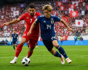 Tunus ve Japonya takımları arasında Dünya Kupası maçında futbolcular top için mücadele ediyor.