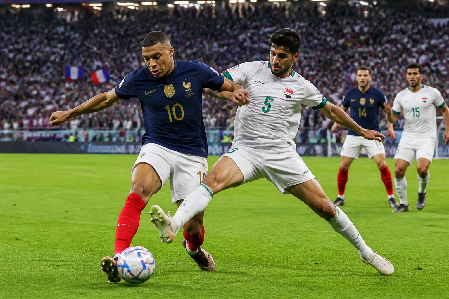 Fransa ve Irak takımlarının futbolcuları, Dünya Kupası maçında sahada top için mücadele ediyor.