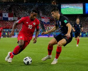 Panama ve Hırvatistan takımlarının Dünya Kupası maçında sahada mücadele eden futbolcular ve tribünde coşkulu taraftarlar.