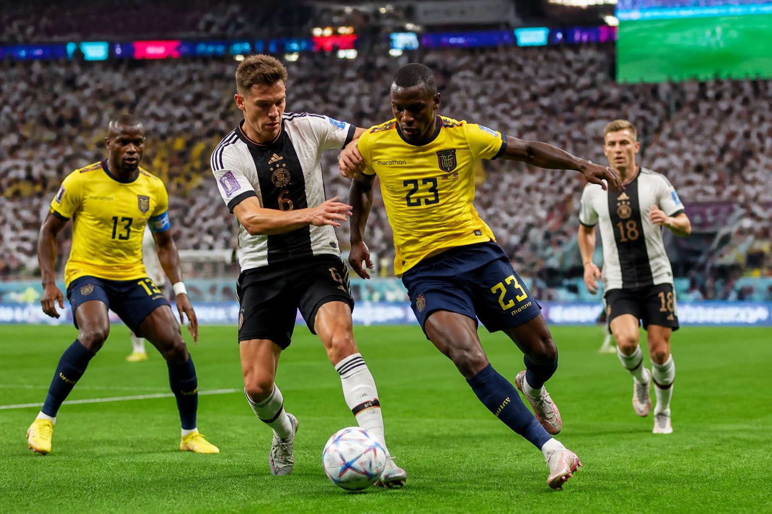 Ekvador ve Almanya futbol takımları, kalabalık bir stadyumda Dünya Kupası maçında mücadele ediyor.