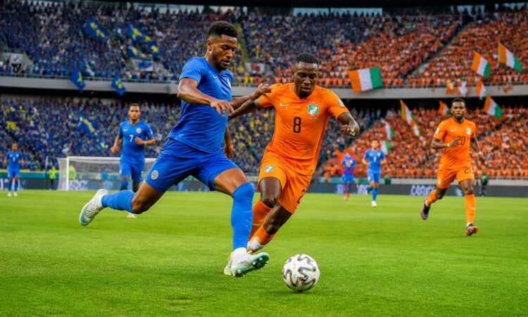 Curaçao ve Fildişi Sahili milli takımları arasında büyük bir stadyumda oynanan heyecanlı futbol maçı.