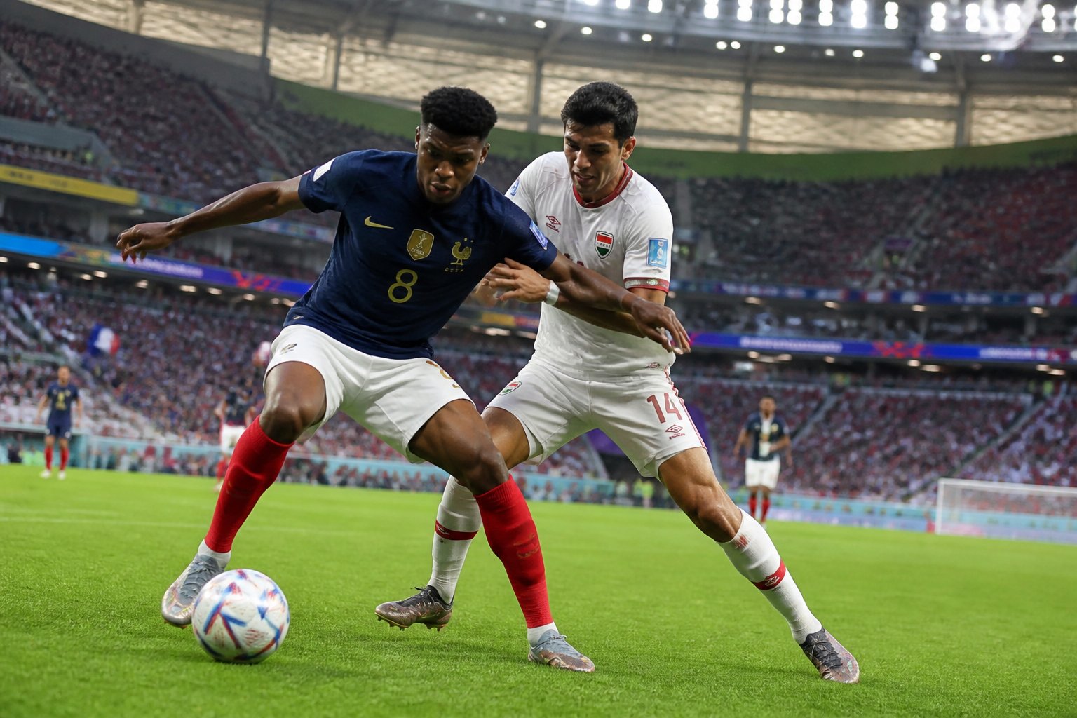 Fransa ve Irak milli takımları arasında Dünya Kupası maçında, iki futbolcu top için mücadele ediyor.