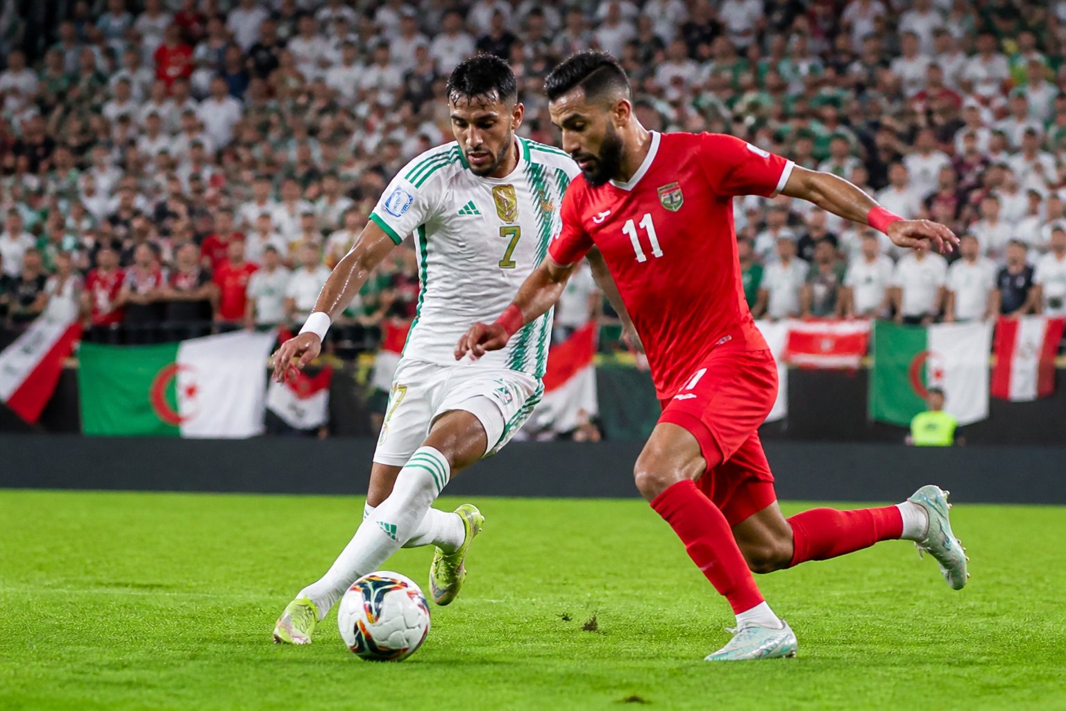 Ürdün ve Cezayir milli takımları arasında Dünya Kupası maçında iki futbolcu top için mücadele ediyor.