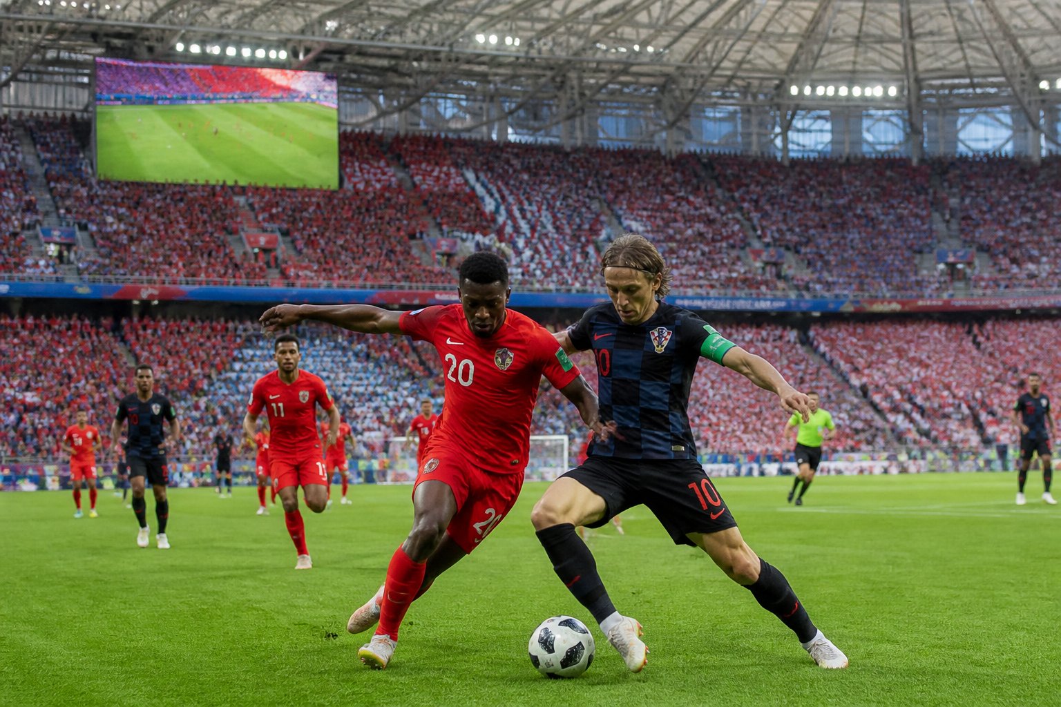 Panama ve Hırvatistan takımları arasında yoğun bir futbol mücadelesi, kalabalık bir stadyumda oynanıyor.