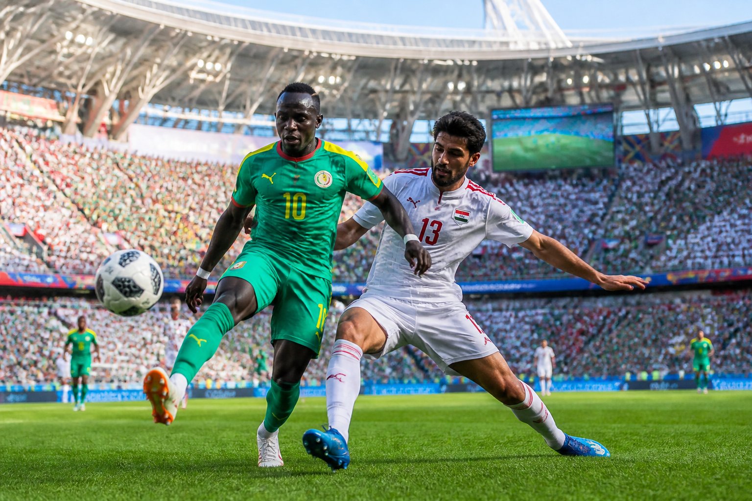 Senegal ve Irak futbol takımları arasında bir Dünya Kupası maçında oyuncular top için mücadele ediyor.